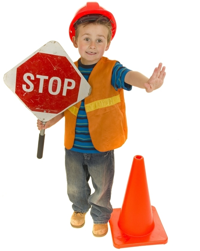 Что делать, если ребенок ведет себя агрессивно - мальчик в костюме дорожного рабочего со знаком стоп