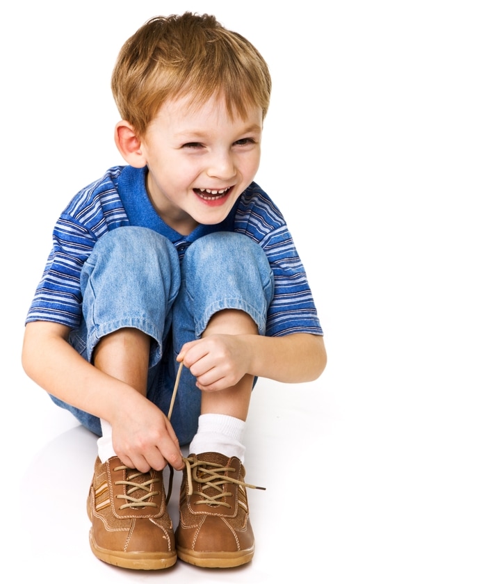 Как научить ребенка завязывать шнурки - смеющийся мальчик затягивает шнурки
