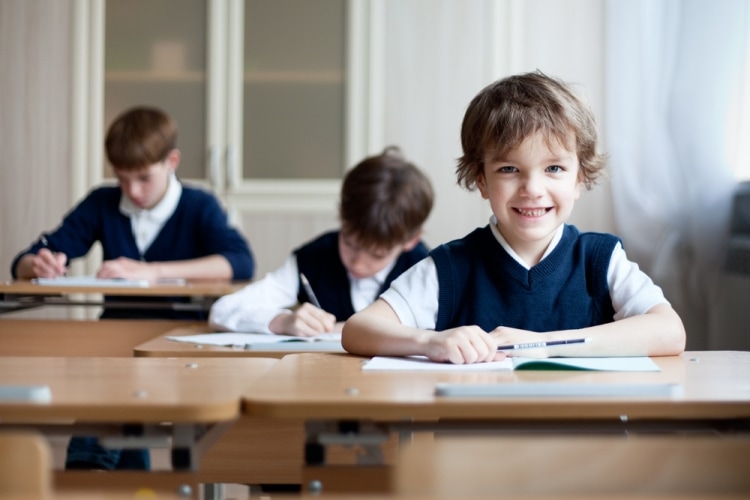 Как выбрать школу для ребенка - улыбающийся мальчик за партой
