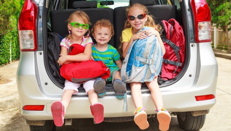 Что взять в дорогу для ребенка - дети с сумками сидят в открытом багажнике