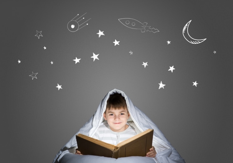 Если ребенок боится спать без света - ребенок под одеялом читает книгу