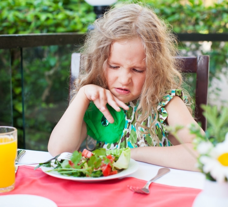 Почему ребенок не ест в детском саду - девочка за столом брезгливо смотрит на салат