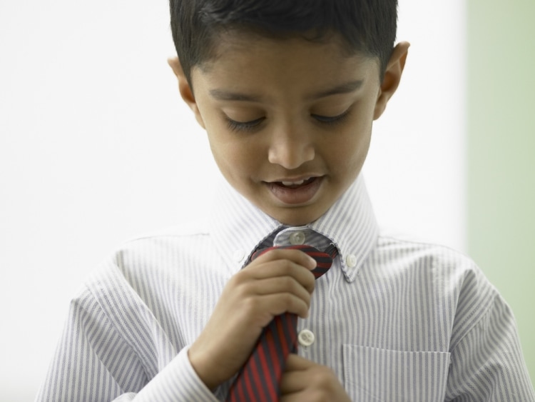 Учим ребенка самостоятельно одеваться - маленький мальчик завязывает галстук
