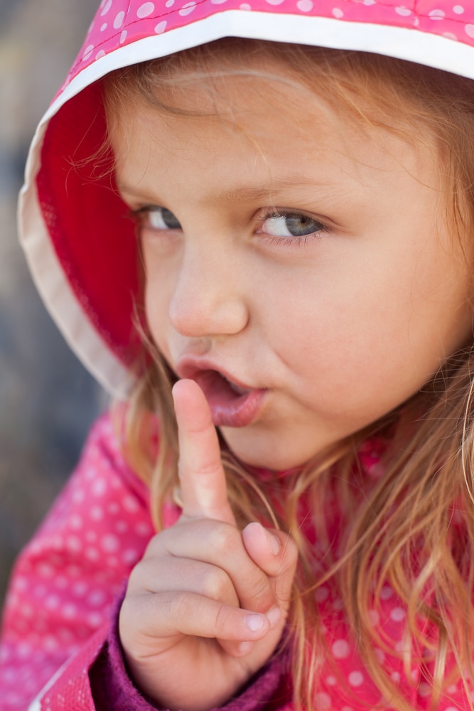 Учим ребенка хранить секреты - маленькая девочка жестом показывает тихо