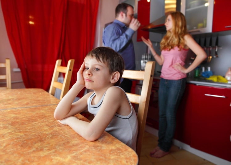 Как отучить ребенка обзываться - мальчик за столом слушает, как ругаются родители